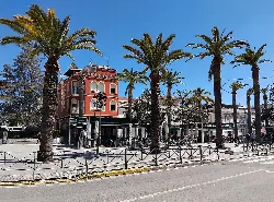 Palmeras y edificio rojo en Paseo Diego Carro, Nueva Carteya.