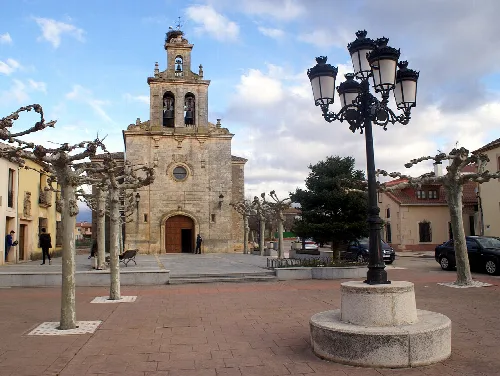 Church of Boceguillas and town square with trees and street lamps.