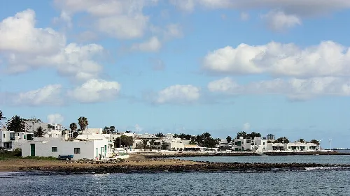 Küste mit weißen Häusern, Palmen und Meer in Playa Honda, San Bartolomé.