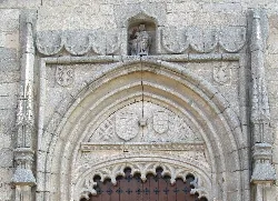 Tympanon des Kirchentors mit Wappen und Schnitzereien.