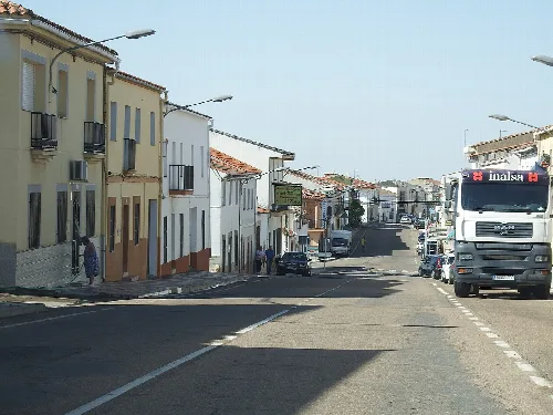 Straße in Zorita mit Häusern und Bus.