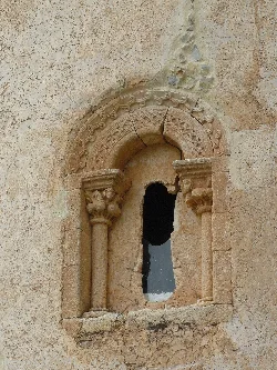 Ventana antigua con marco decorativo en piedra en la iglesia de Santa María.