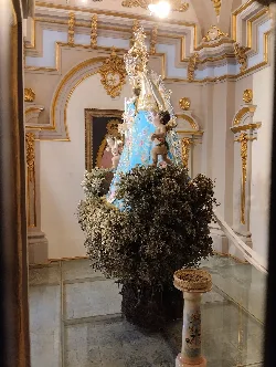 Statue der Virgen de Cortes auf einem Altar mit goldenen Verzierungen und religiösen Details.