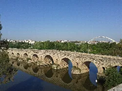 Römische Brücke von Mérida mit Steinbögen und Lusitania-Brücke im Hintergrund.