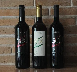 Three bottles of Ceclavín's pitarra wine on a wooden surface.