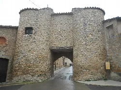 Stone gate with round towers and arch in Sarrión.