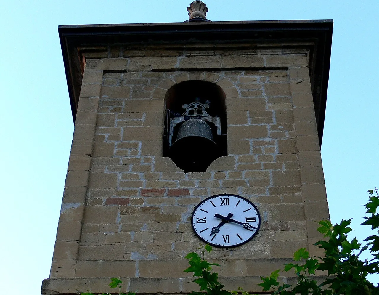 Stone bell tower with clock and bell in Cihuri, La Rioja.