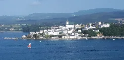 Vista de Castropol y la Ría de Eo desde Ribadeo con montañas en el fondo.
