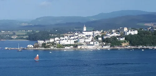 Vista de Castropol y la Ría de Eo desde Ribadeo con montañas en el fondo.