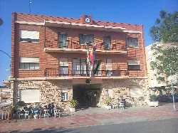 Almussafes town hall building with flags and a clock on top.