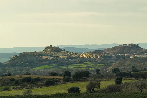 Panoramablick auf grüne Hügel und einen kleinen Ort auf dem Hügel in La Sotonera.