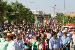 Large procession with many people and floats in the street in El Viso del Alcor.