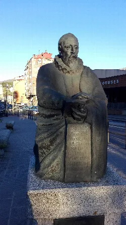 Cervantes-Statue in Béjar mit Gebäuden und blauem Himmel.