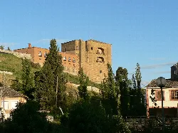 Torre del Caracol in Benavente, Zamora, with houses and trees.