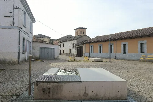 Platz mit Brunnen, Bänken und Gebäuden in Mansilla Mayor, León.
