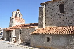 Stone church with tower and red tiled roof in Villaflor.