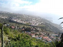 Landschaft von El Sauzal mit Häusern an den Hügeln und dem Meer im Hintergrund.