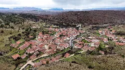 Aerial view of Moncalvillo with houses and rural landscape.