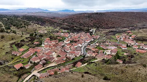 Aerial view of Moncalvillo with houses and rural landscape.