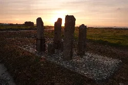 Large, strange stones in a field at sunset.