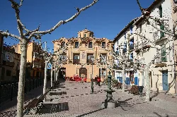 Platz mit blattlosen Bäumen, Brunnen und Gebäuden in Villarroya de la Sierra.