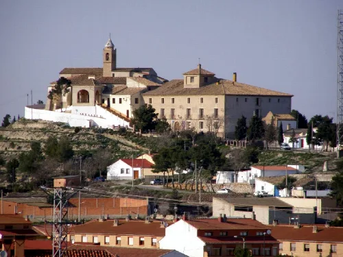 View of a town with a church on the hill and surrounding houses.