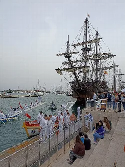 Barco antiguo en el puerto de Castellón con personas y actividades en el muelle.
