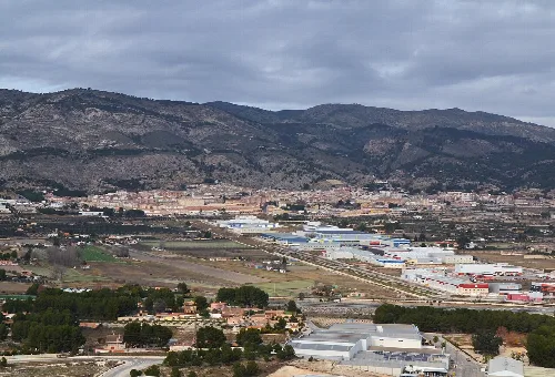 Blick auf Onil vom Castalla-Schloss, mit Bergen und Industriegebieten.