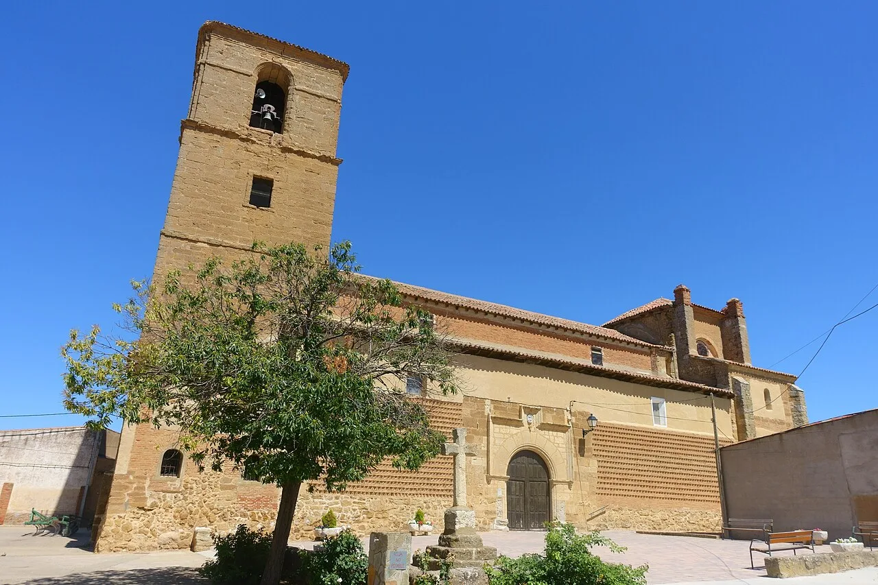 Iglesia de la Asunción de Nuestra Señora con torre y fachada de piedra en Villamayor de Campos.