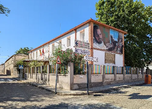 Edificio escolar con mural y banderas en Mascaraque, Toledo.