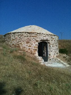 Stone circular icehouse with iron door in a Zaragoza countryside.
