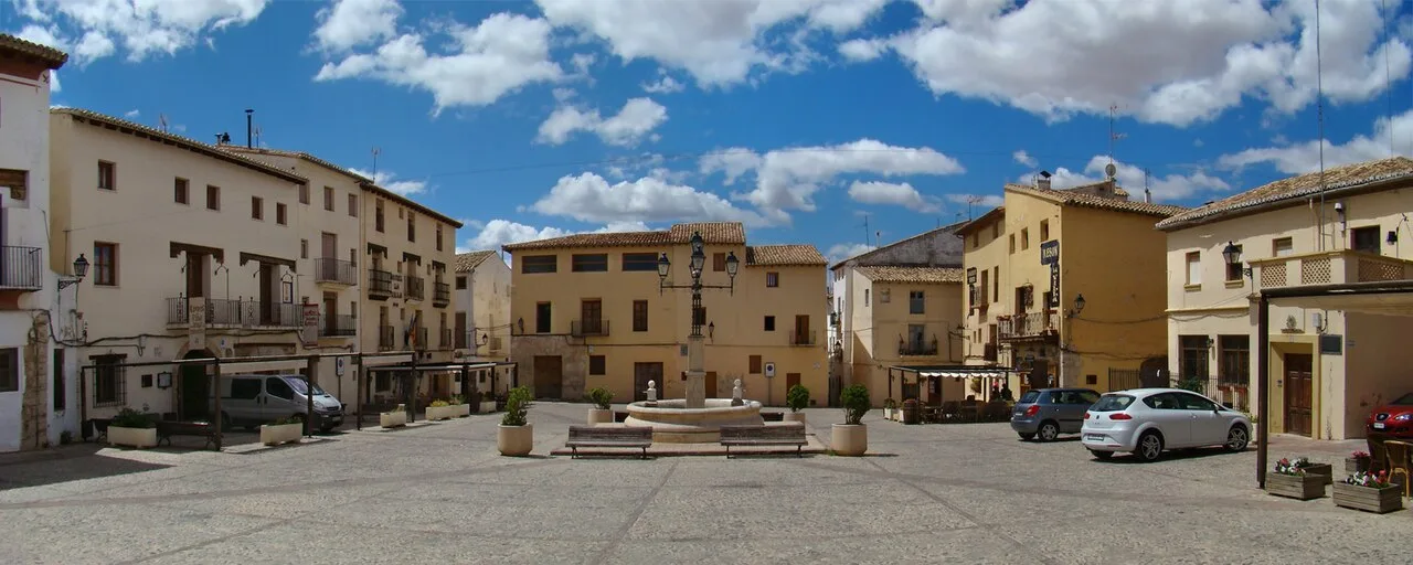 Platz von La Villa in Requena mit Gebäuden und Brunnen in der Mitte.