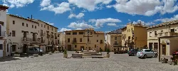 Platz von La Villa in Requena mit Gebäuden und Brunnen in der Mitte.