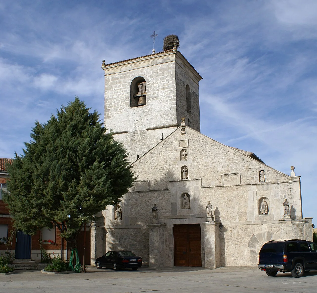 Church of Our Lady of Assumption in Cogeces del Monte with tower and stone facade.