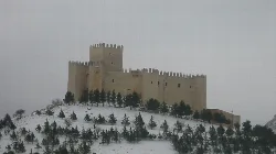 Schloss Vélez-Blanco mit Schnee und Bäumen an einem bewölkten Tag.