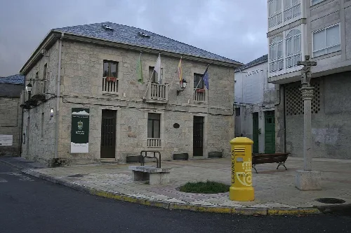 Steinernes Gebäude mit Flaggen und Straßenlaterne auf dem Platz.