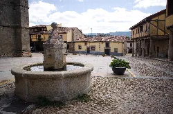 Steinbrunnen auf dem Hauptplatz von Bonilla de la Sierra mit historischen Gebäuden.