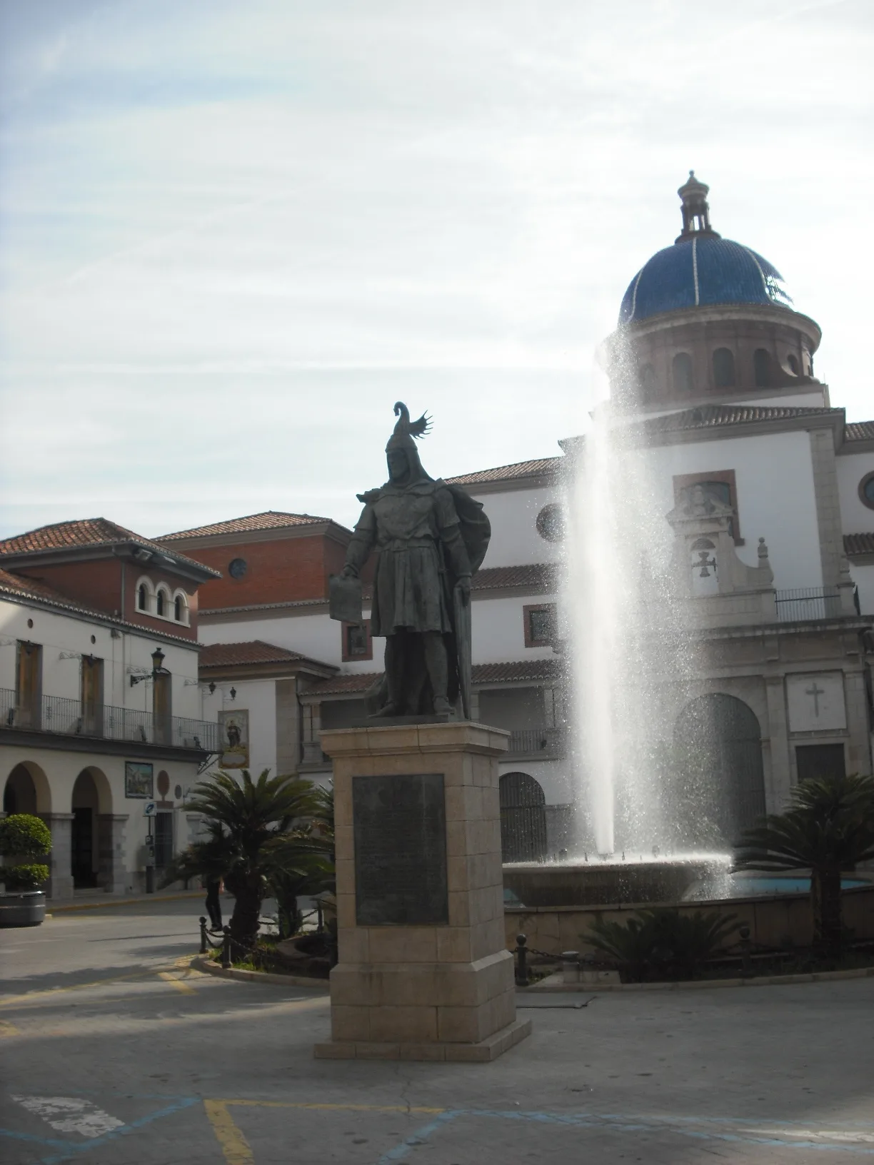 Statue of Jaume I, fountain, and church in Nules' main square.
