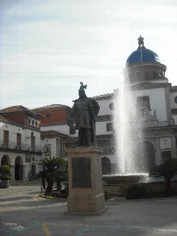Statue of Jaume I, fountain, and church in Nules' main square.