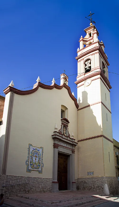 Fassade der Kirche mit Glockenturm und roten Details in Massanassa.