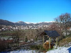 Paisaje de Fabero con montañas nevadas y un pueblo en el valle.