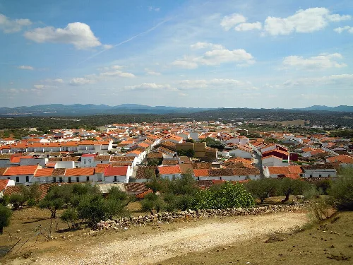 Panoramablick auf Häuser mit roten Dächern und Bäumen in Santa Olalla del Cala.