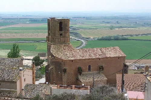 Kirche mit Turm in Piracés, Huesca, umgeben von Feldern.