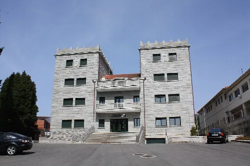 Gebäude des Rathauses von Barro mit zwei Türmen und Treppen vorne.