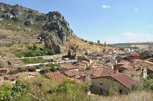 Panoramic view of Pancorbo with houses, castle, and mountains.
