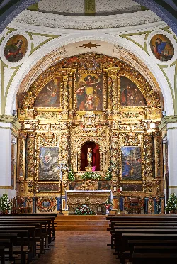 Altar barroco con pinturas y detalles dorados en la Ermita de la Virgen del Yugo en Arguedas.