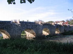 Stone bridge with arches over a river in Iruña de Oca.