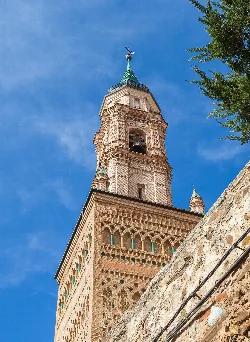 Torre de ladrillo de la iglesia Santa María en Ateca con cielo azul.