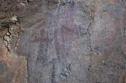 Pinturas rupestres en la pared de una cueva de piedra.