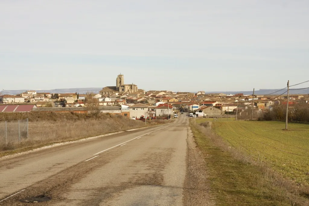 Ländliche Straße mit Blick auf Sasamón und seine Kirche im Hintergrund.